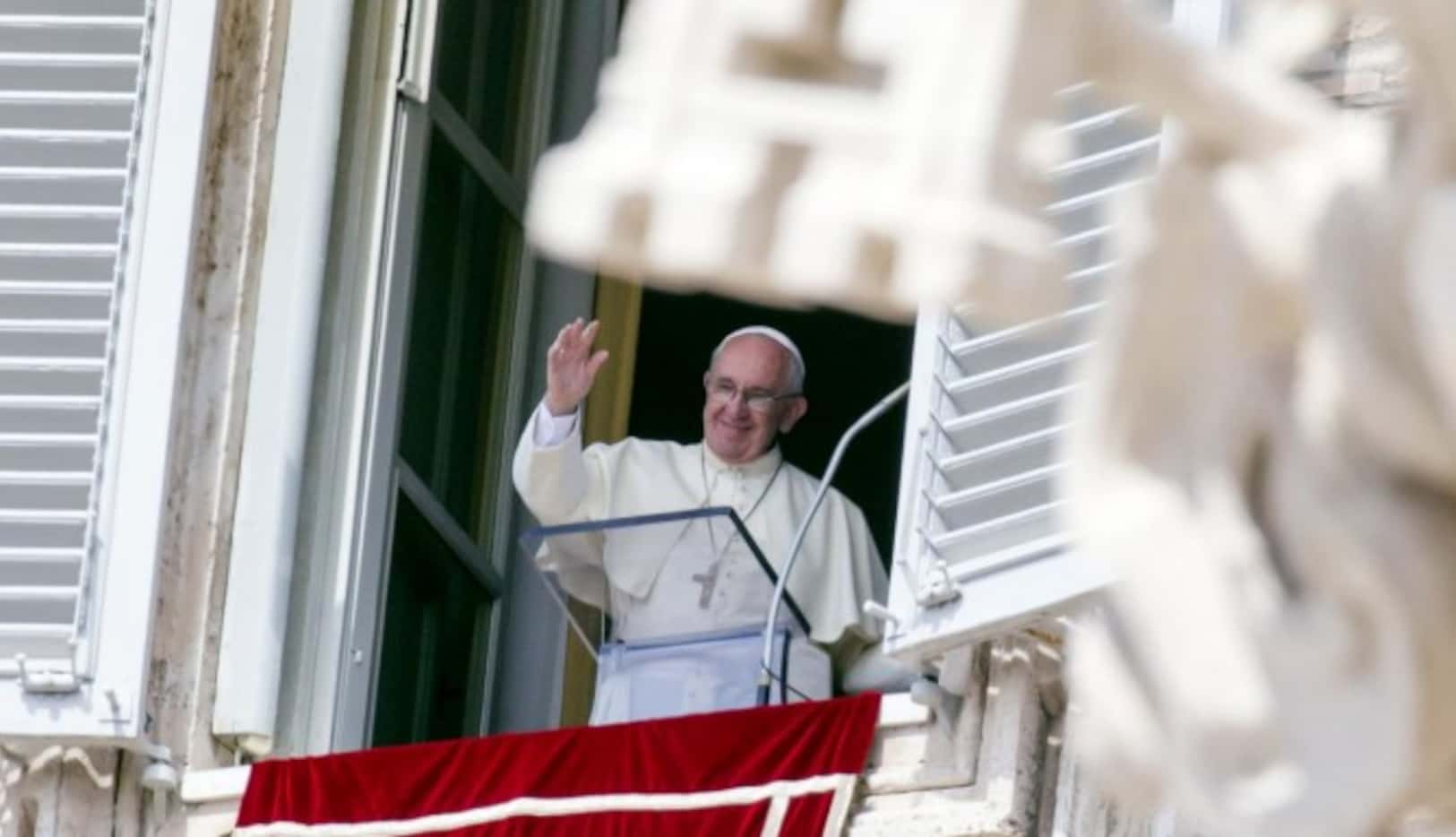 El papa Francisco saluda a los fieles desde una ventana con vista a la Plaza de San Pedro,...