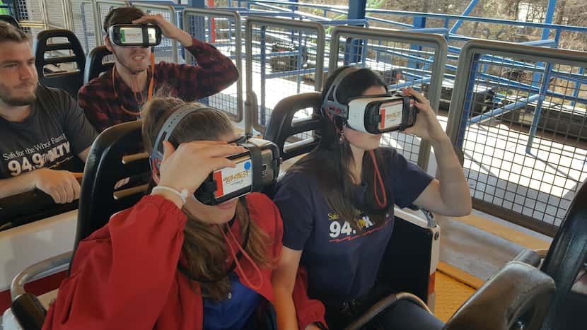 Staff members of 94.9 KLTY-FM adjust their VR goggles before riding the Galactic Attack at...