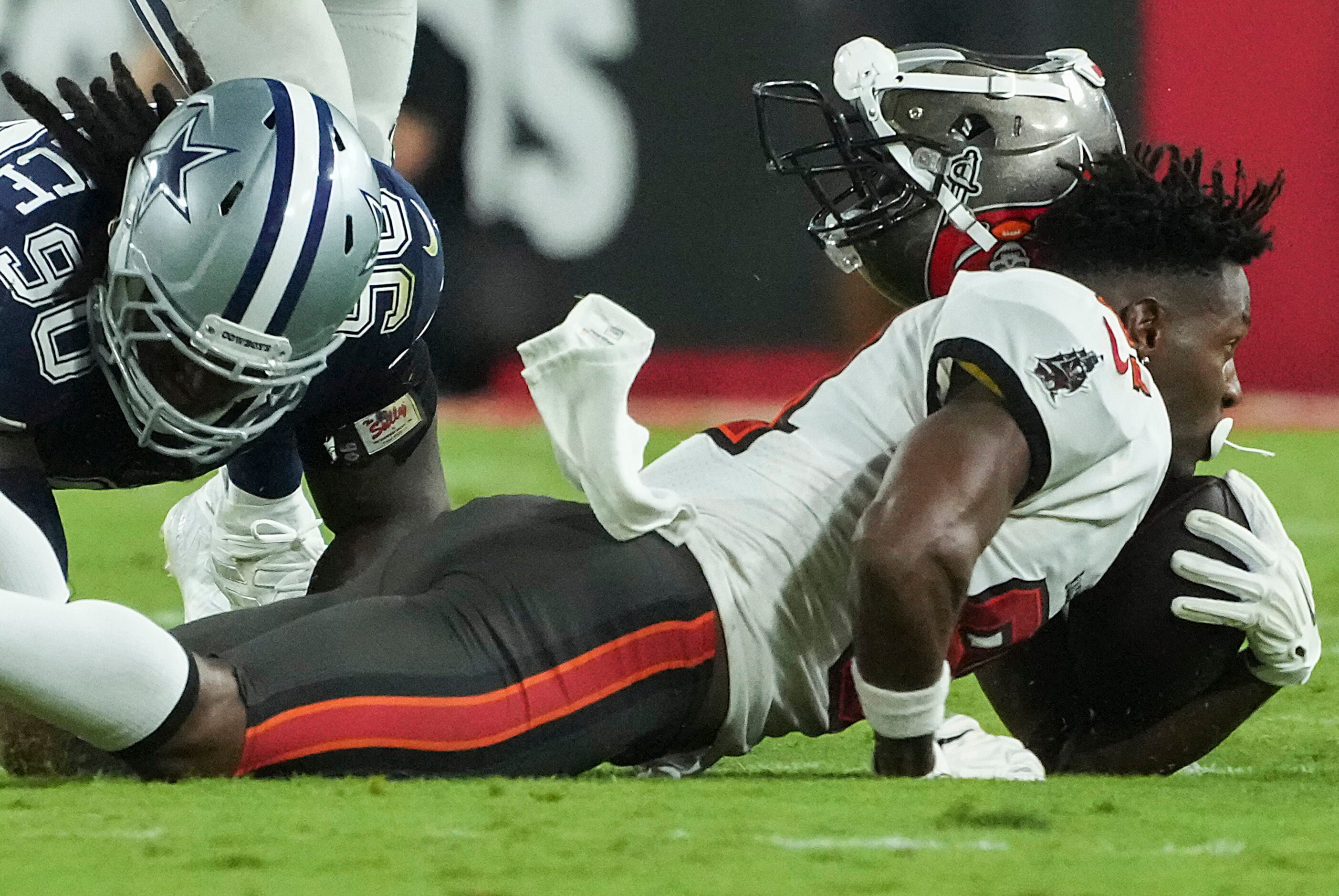 Tampa Bay Buccaneers wide receiver Antonio Brown (81) loses his helmet as he is brought down...