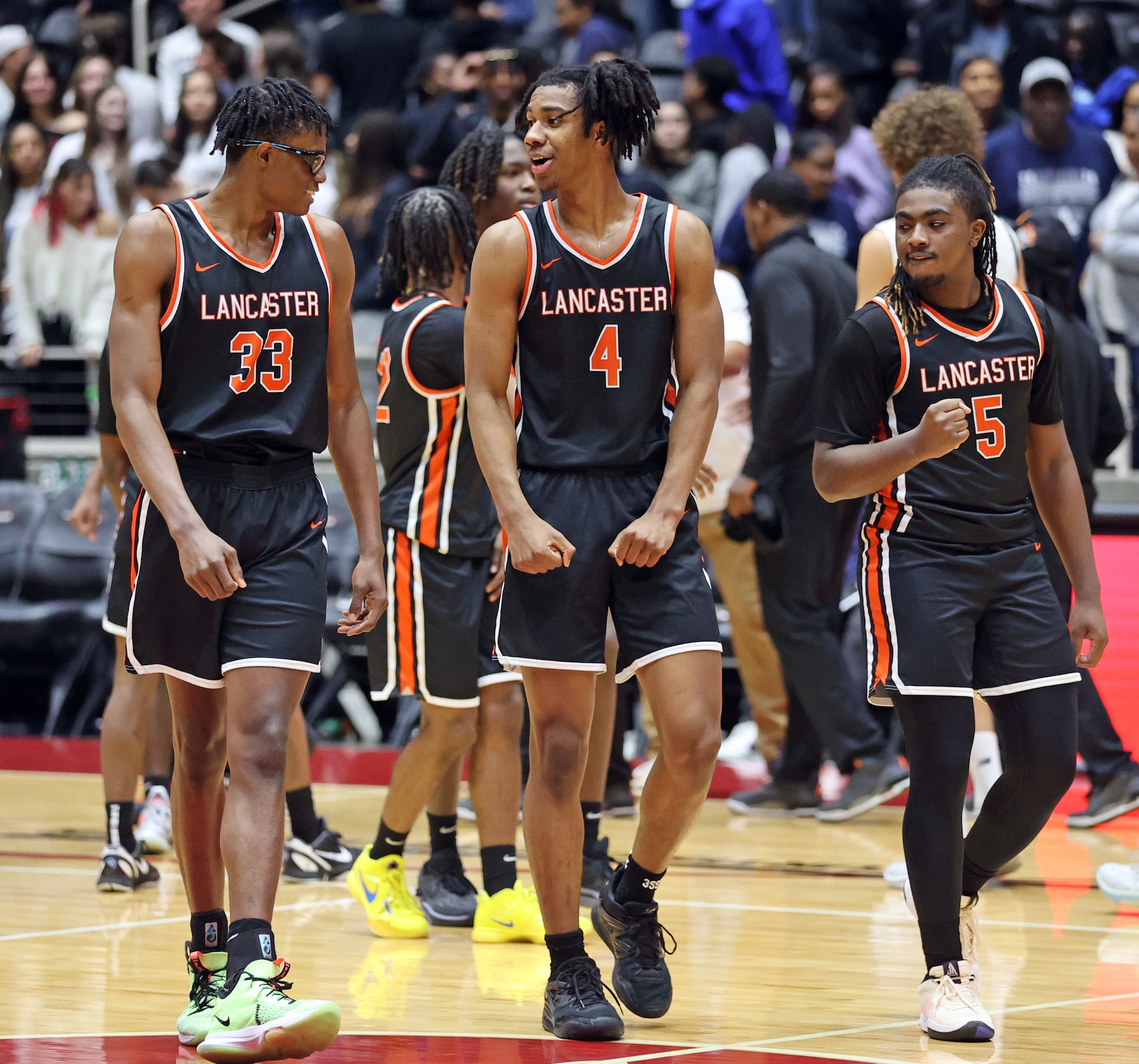 Lancaster's Amari Reed (33), Dillon Battie (4) and Mario Perry (5) are happy, as the leave...