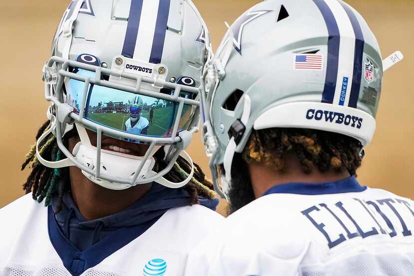 El receptor abierto de los Cowboys, CeeDee Lamb (izq), habla con el corredor Ezekiel...