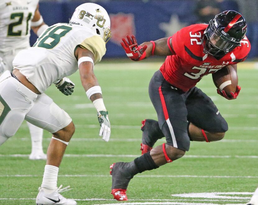 Texas Tech running back Da'Leon Ward (32) gets set to stiff-arm Baylor safety Chance Waz...