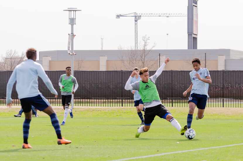 Trialist Lucio Martinez (foreground. green bib) reaches for the ball against Swope Park...