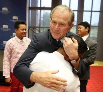  Former President George W. Bush greets Chit Min Lay following the graduation ceremony of...