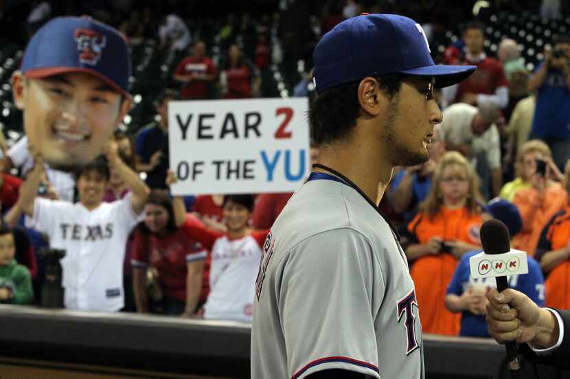 Yu Darvish is interviewed by the Japanese media after the Rangers' 7-0 win during the Texas...