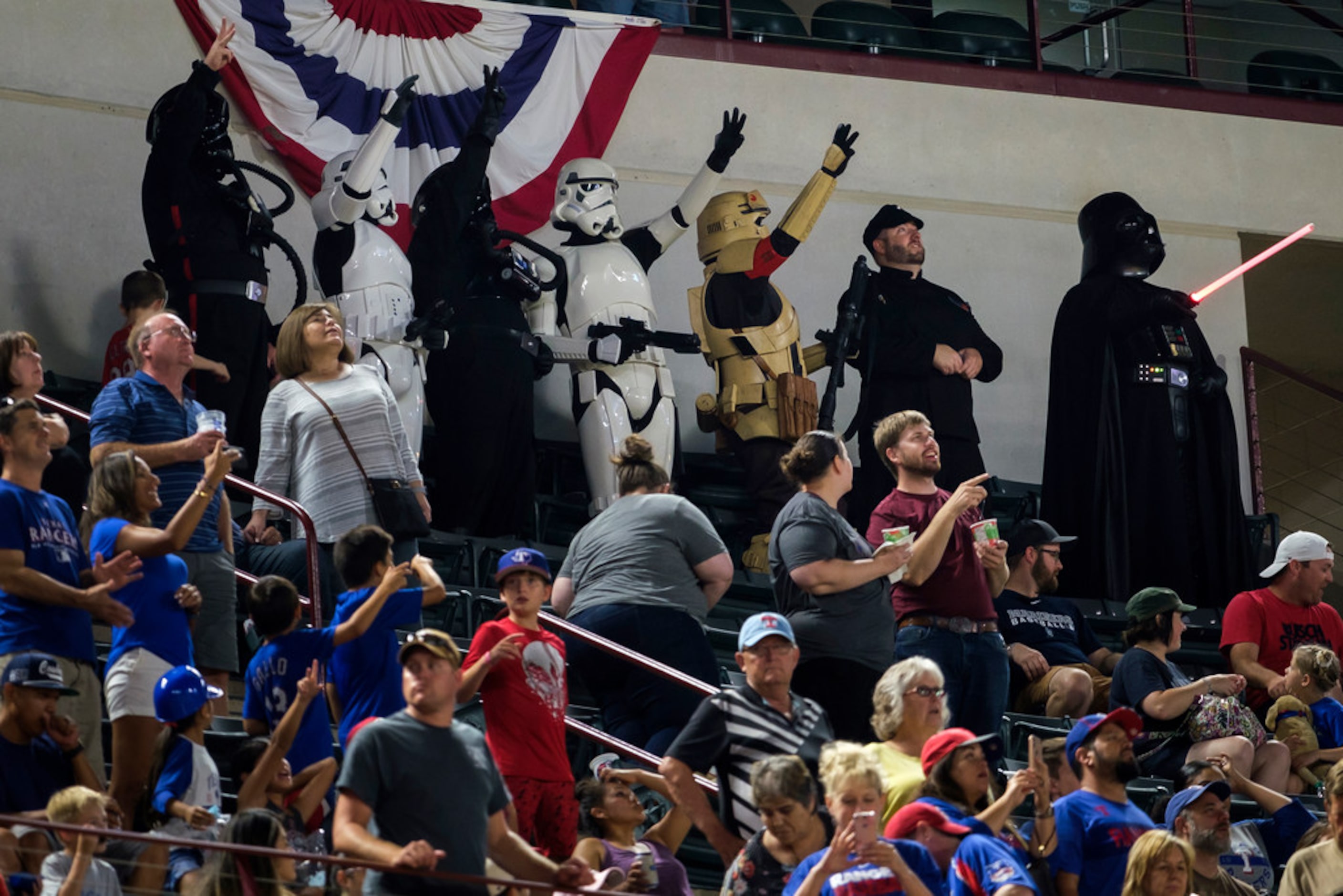 A group in costume as Storm Troppers, as well as Darth Vadar, from Star Wars, sing along to...