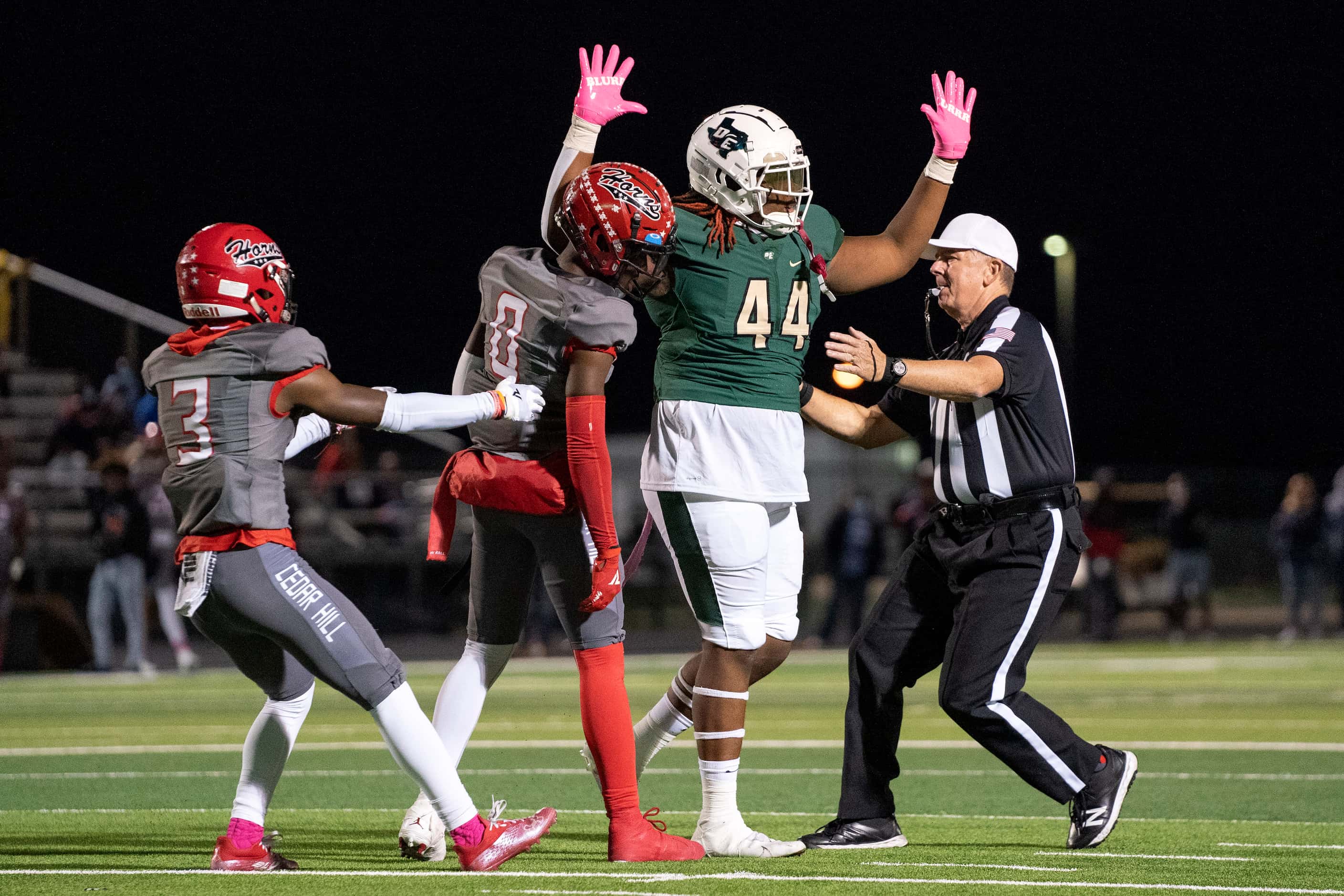 A referee and Cedar Hill senior defensive back Donovan Hubbard (3) step in to break up some...