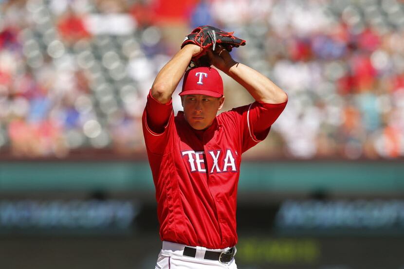 Texas Rangers starting pitcher Derek Holland (45) starts his windup as he throws against the...