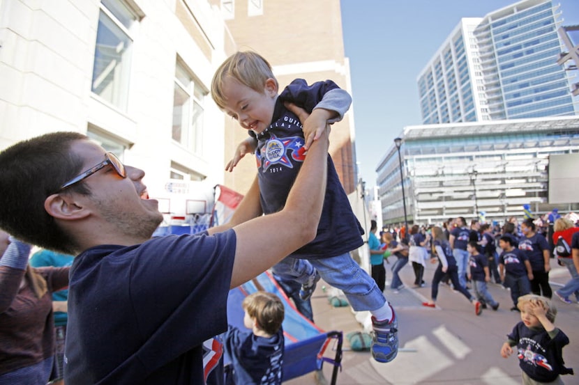 Jose Rueda, 19, lifts his friend Donovan Sparzak, 3, while playing with him during the Down...