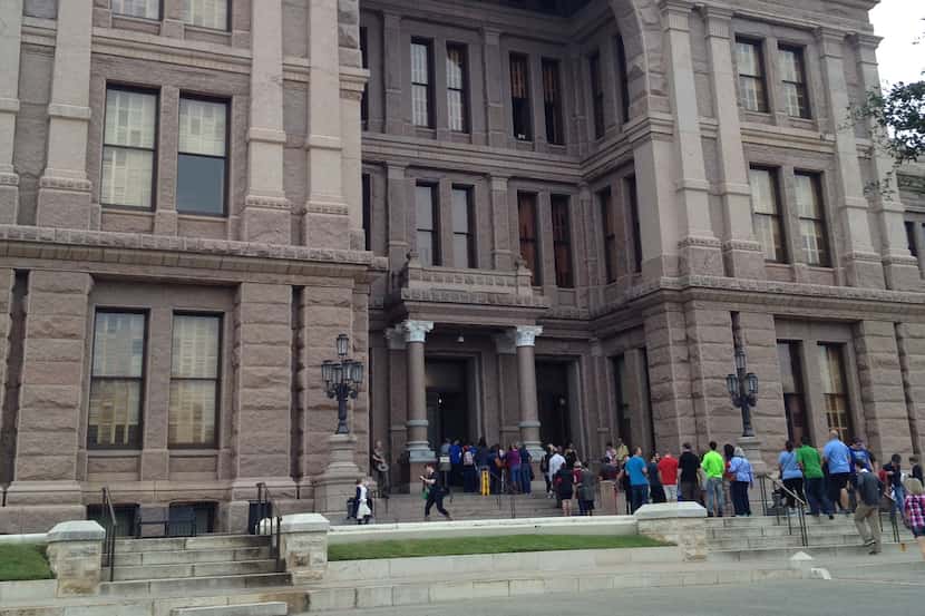 Texas Book Festival attendees wait to enter to Capitol on Saturday