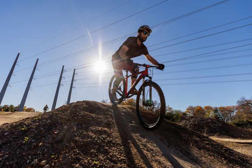 Anthony Fopp from Princeton jumps his mountain bike at a trail adjacent to the The Trinity...