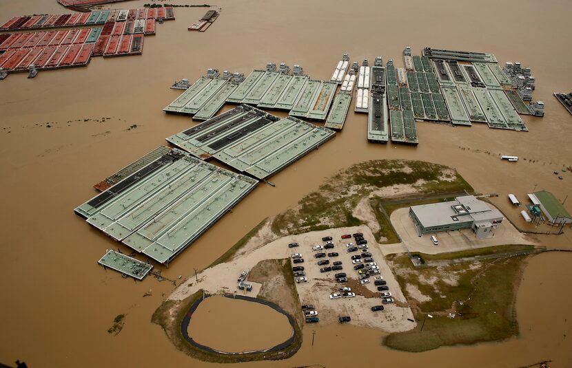 Barges are secured by tugboats in the flood swollen Burnet Bay along the Houston Ship...