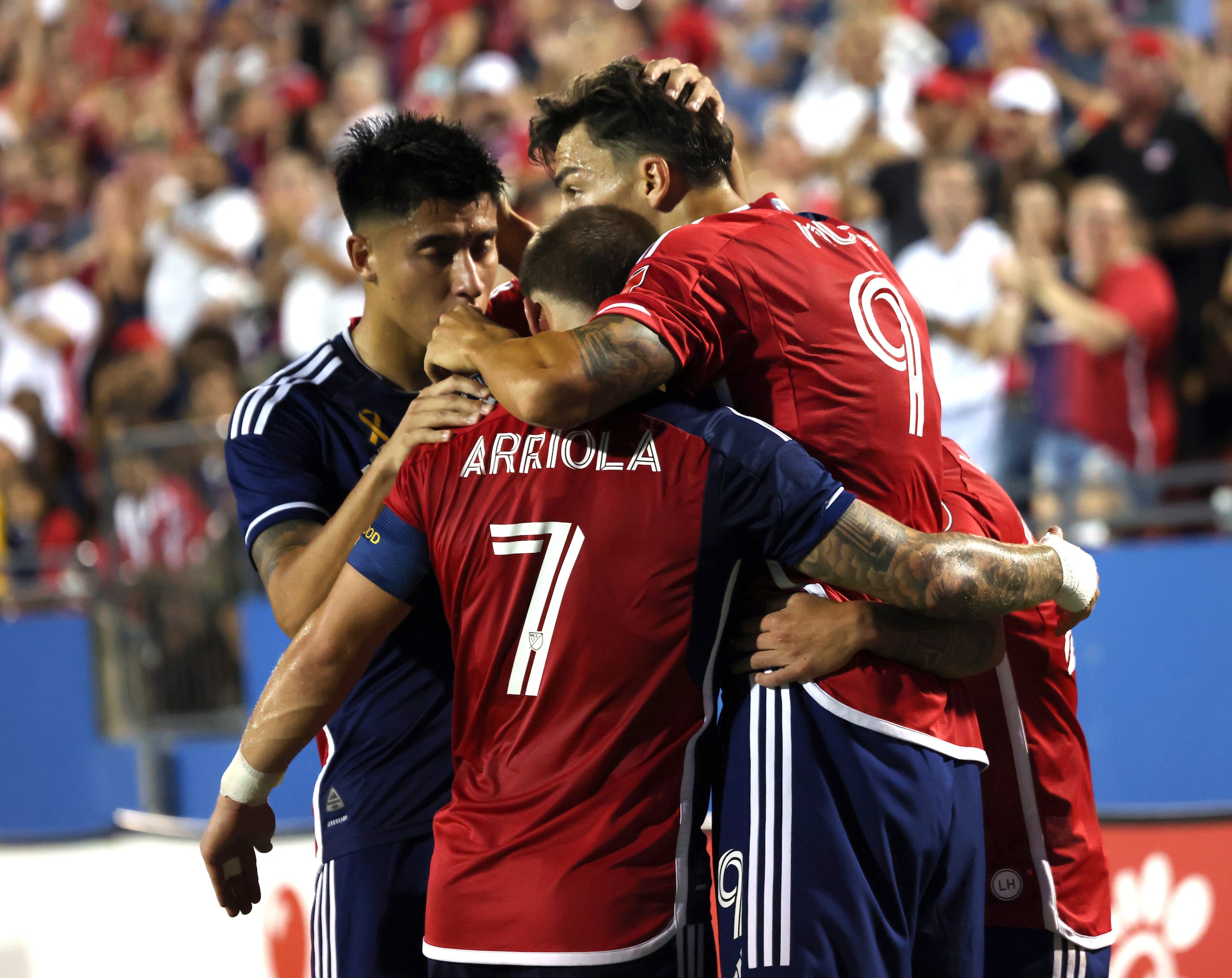 FC Dallas attacker Peter Musa (9), center top, receives congratulations from Paul Arriola...