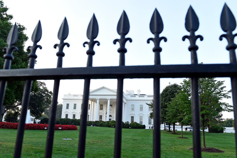 The White House is framed with the fence on the North side of the White House in Washington,...