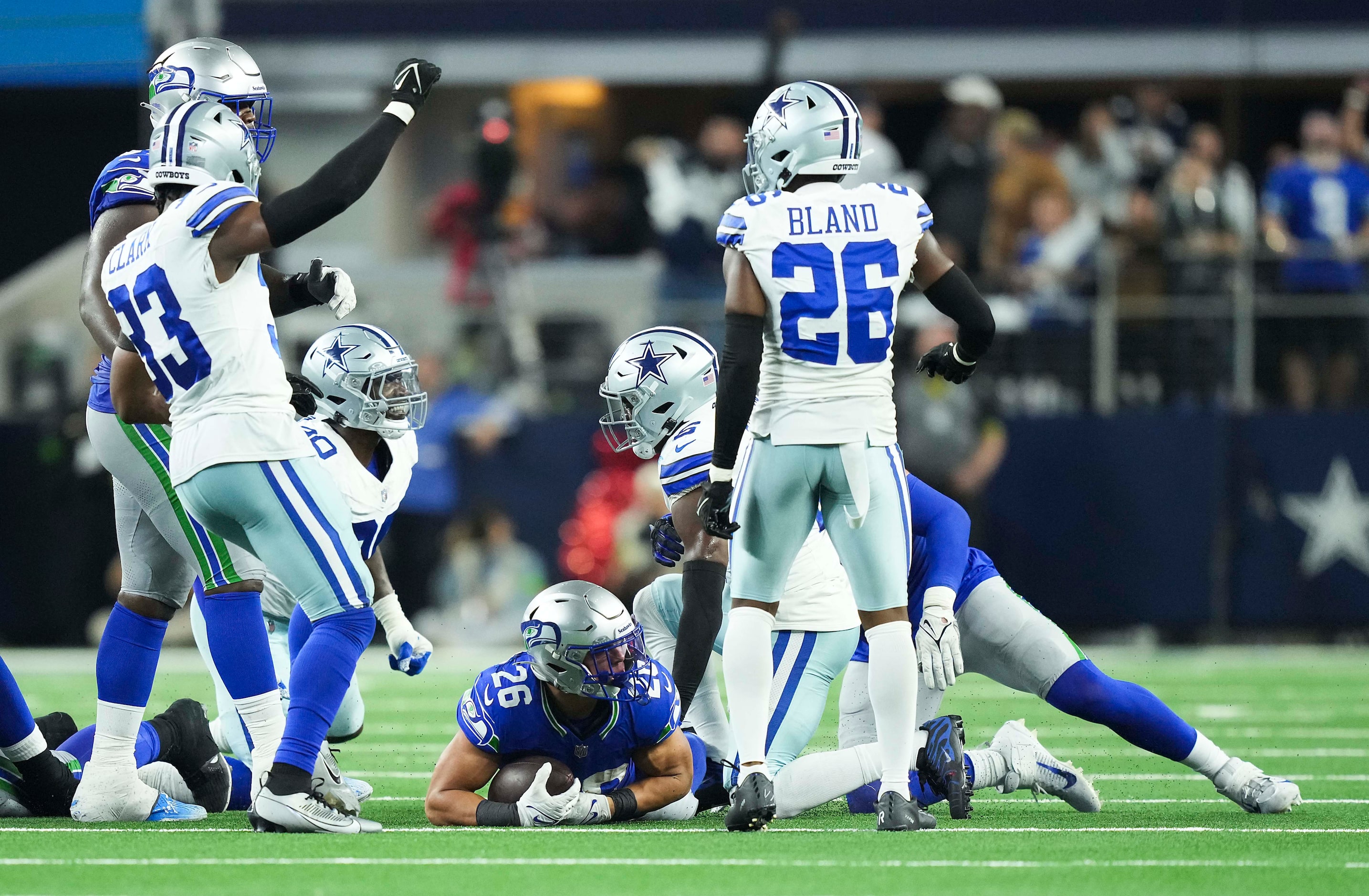 Dallas Cowboys players celebrate after Seattle Seahawks running back Zach Charbonnet (26)...