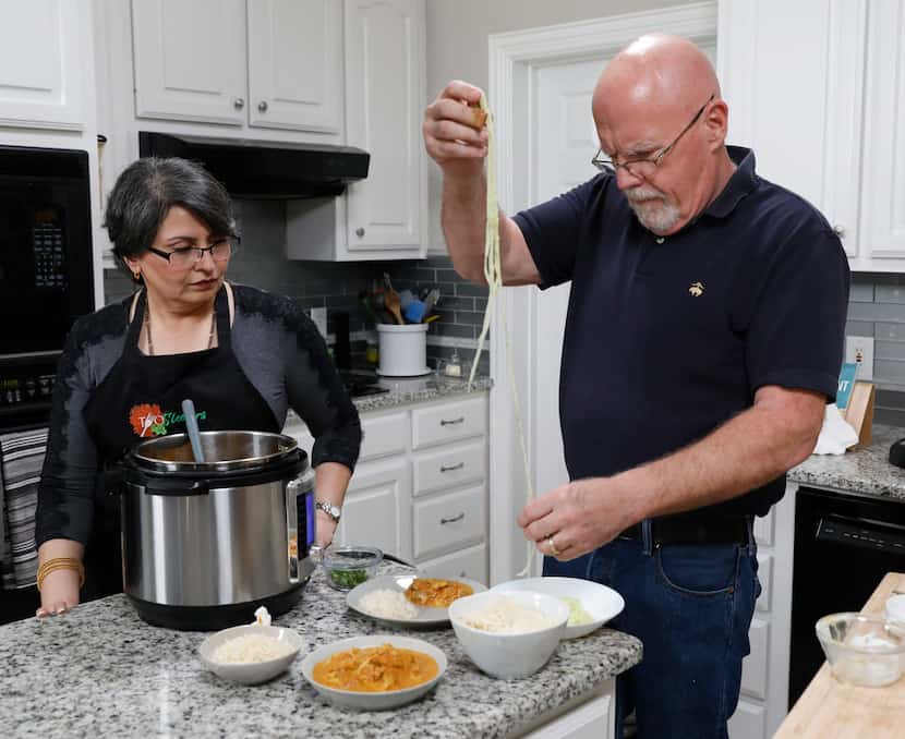 Urvashi Pitre, left, watches her husband, Roger Gorman, place spiralized cucumber noodles on...