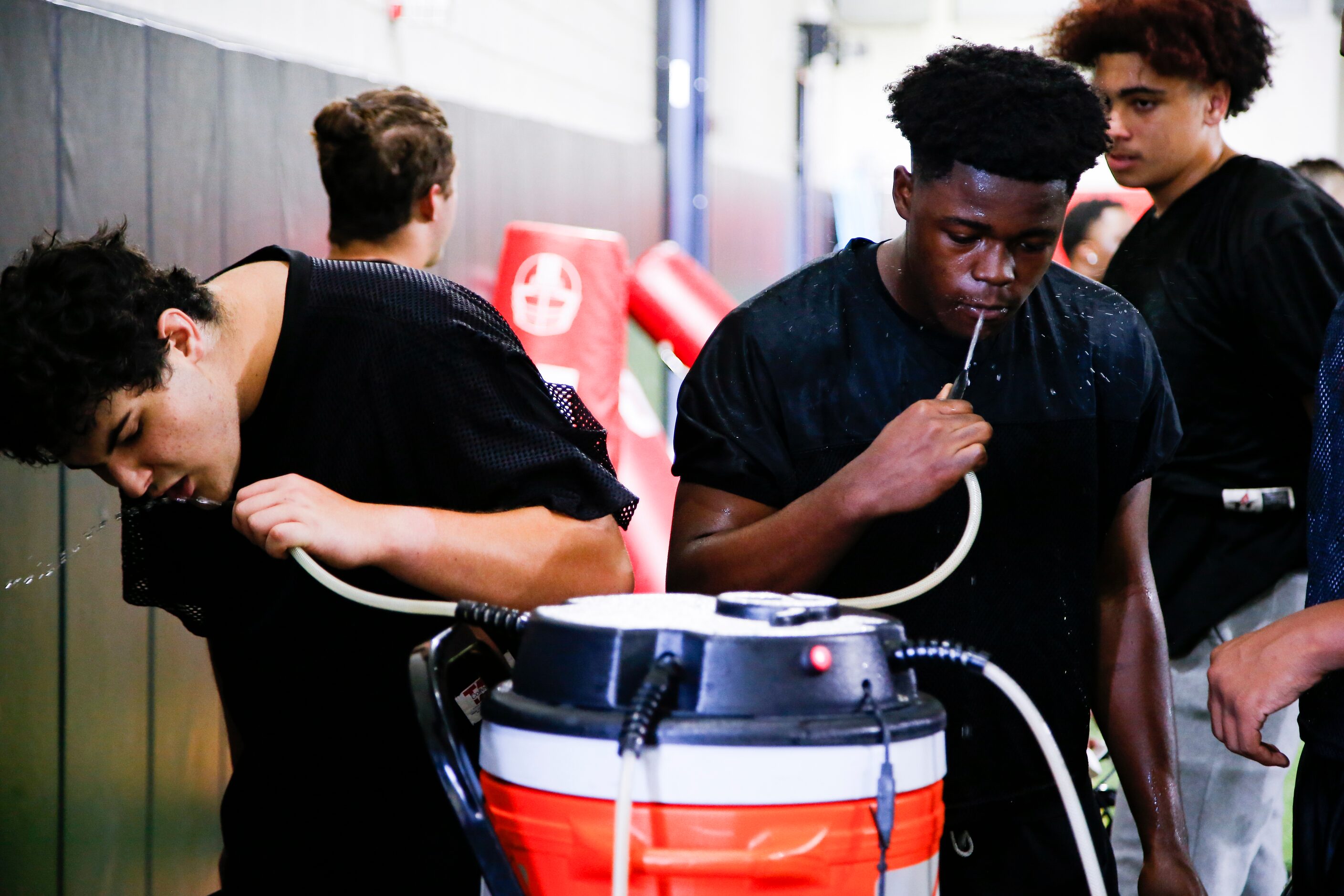 Euless Trinity varsity football players take a water break during a practice at Euless...