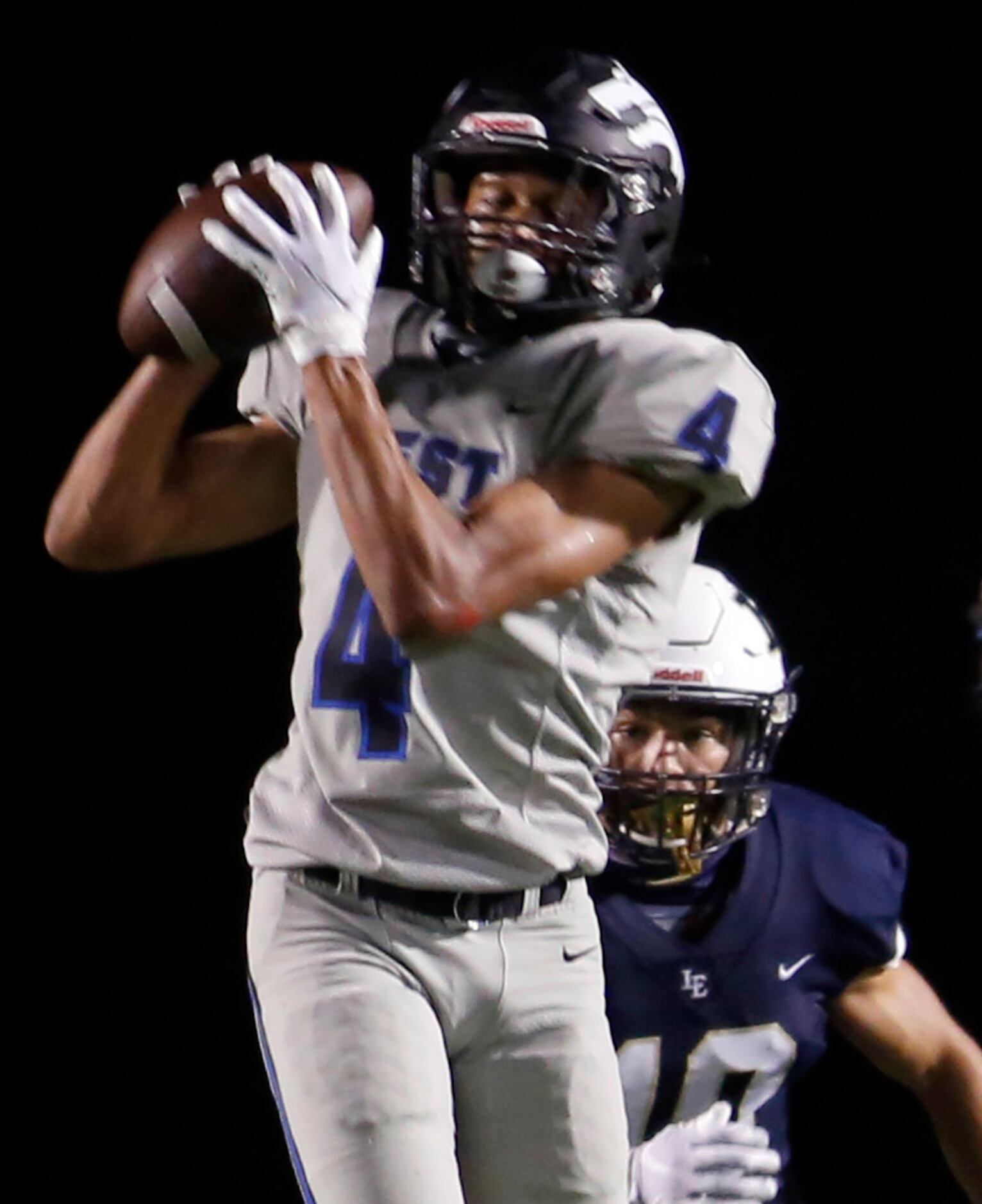 Plano West receiver Tyler Harrell (4) leaps to pull down a reception in front of Little Elm...