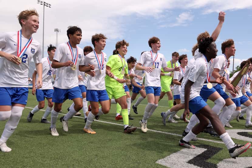 Midlothian players race to greet cheering fans in the stands after receiving their state...