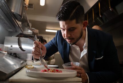 Chef and CEO Julian Rodarte of the Trinity Groves Restaurant Group, adds finishing touches...