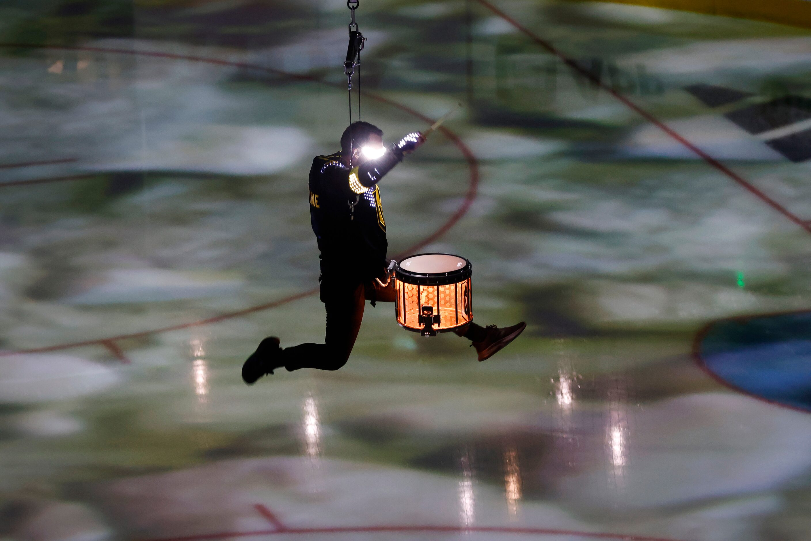 Flying drummers are raised and lowered from the rafters during a pregame performance before...