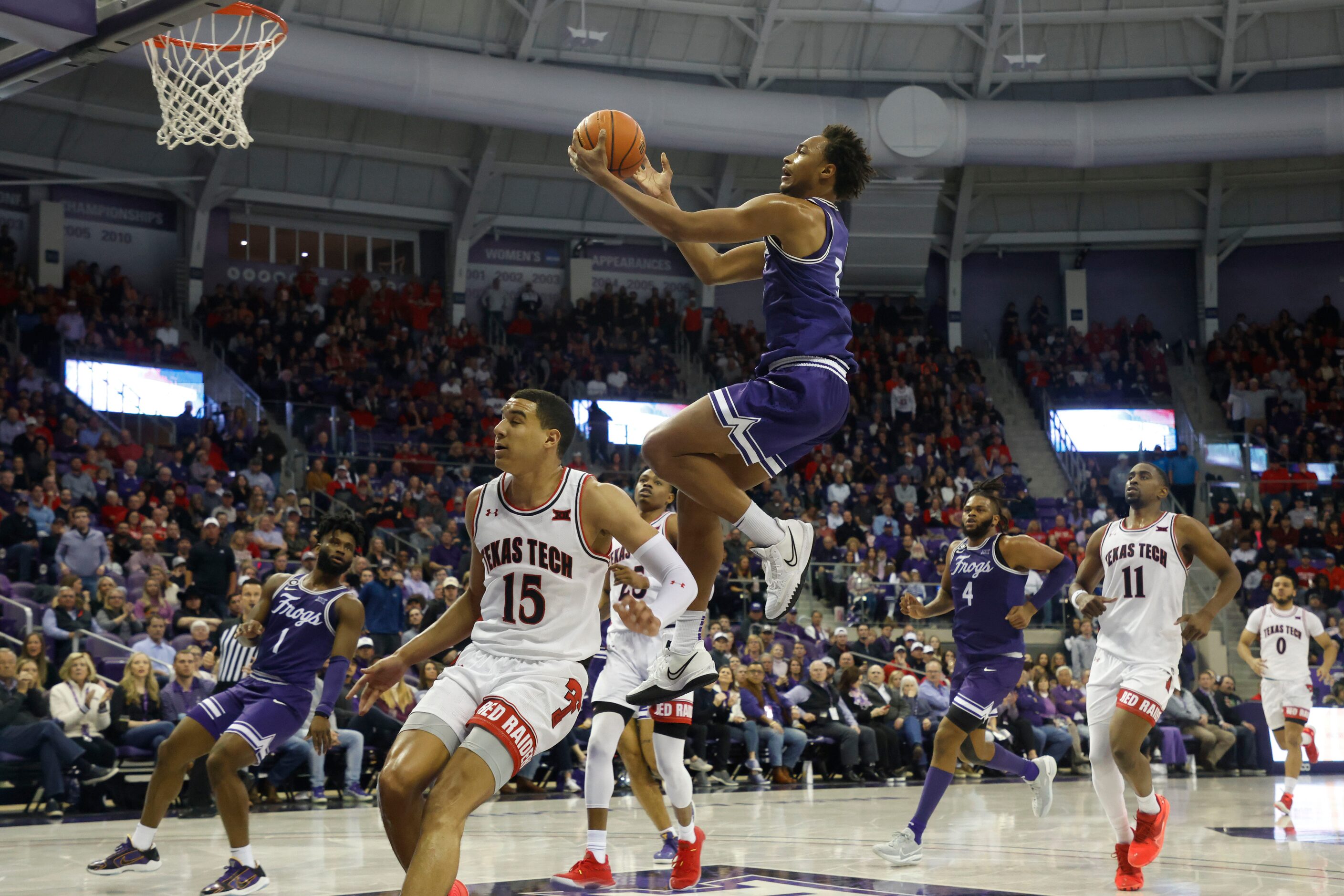 TCU forward Chuck O'Bannon Jr. (5) makes a layup in front of Texas Tech guard Kevin McCullar...