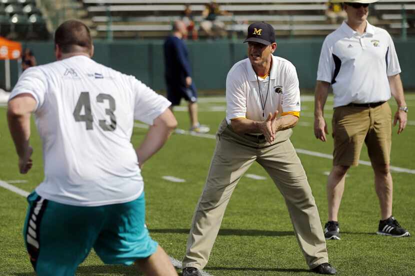 Michigan Wolverines head coach Jim Harbaugh (center) conducts a drill during the Showtyme...