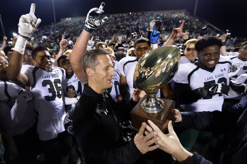Mansfield Lake Ridge coach Kirk Thor receives the trophy after beating Aledo in a state...