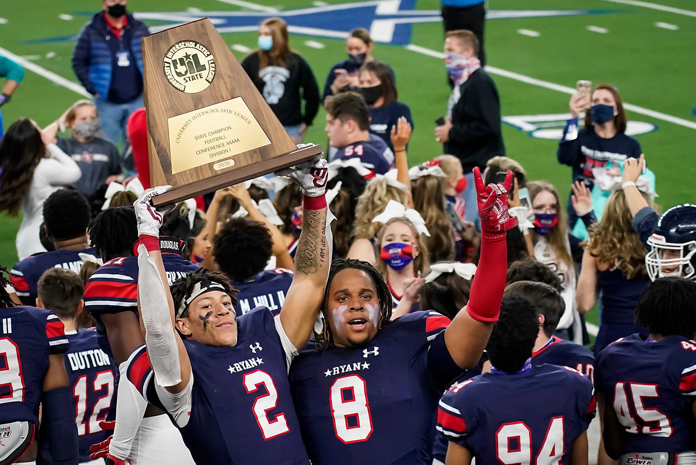 Denton Ryan wide receiver Billy Bowman Jr. (2) hoists the championship trophy with teammate...