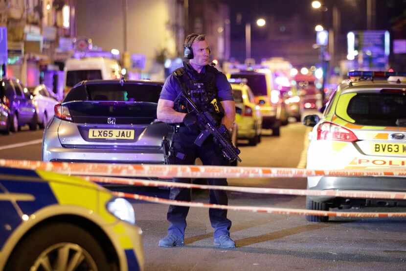 An armed police officer mans a cordon on the Seven Sisters Road at Finsbury Park where a...