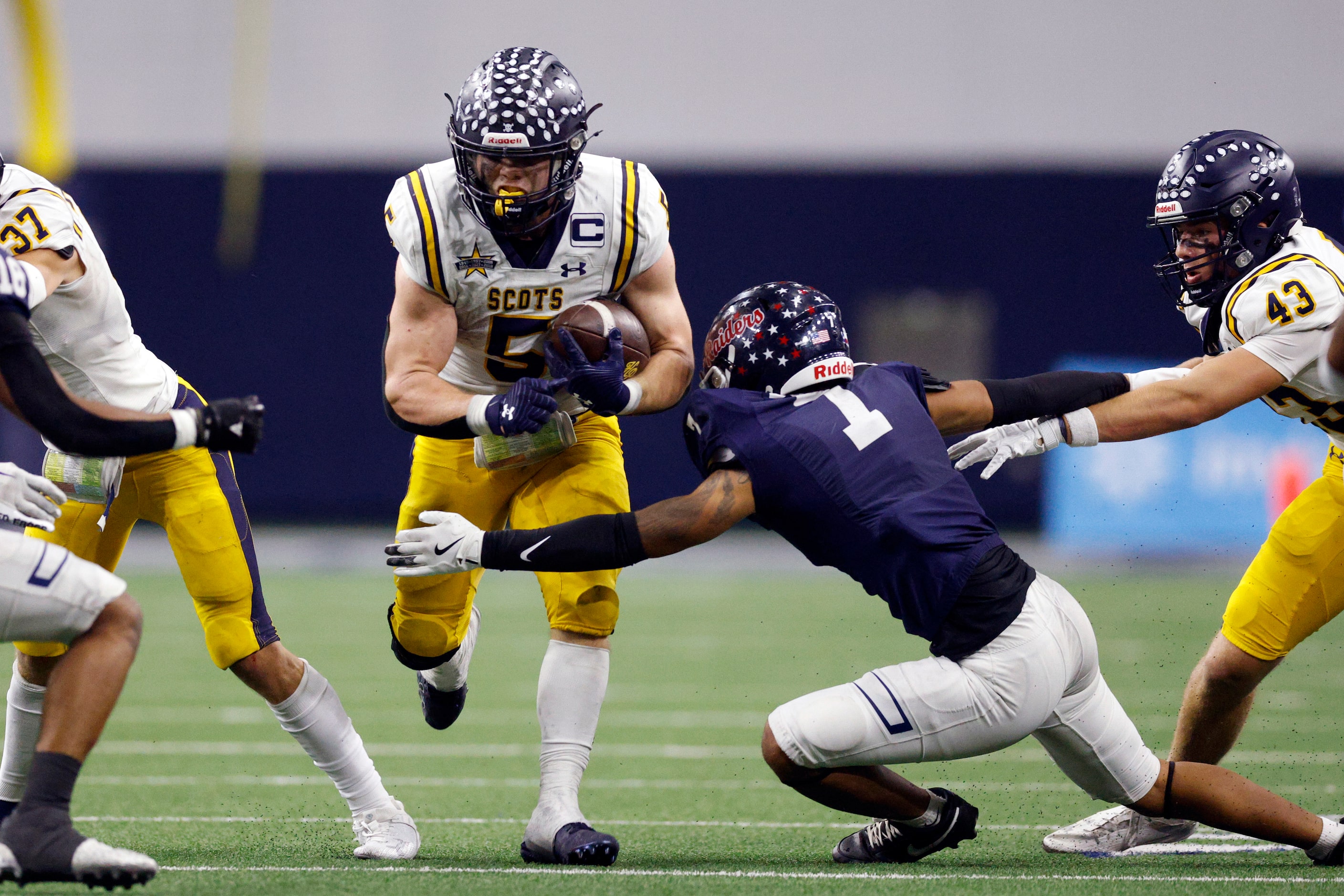 Highland Park running back James Lancaster (5) runs through the arm of Denton Ryan defensive...