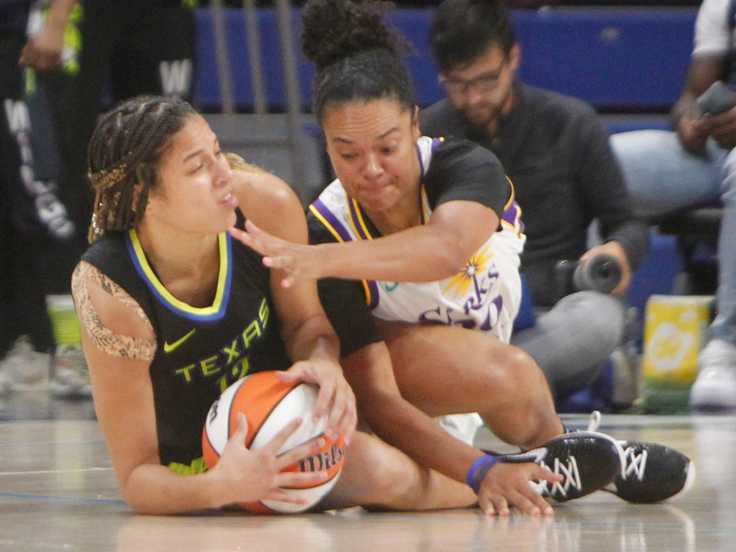 Dallas Wings guard Veronica Burton (12), left, battles with LA Sparks guard Kristi Toliver...