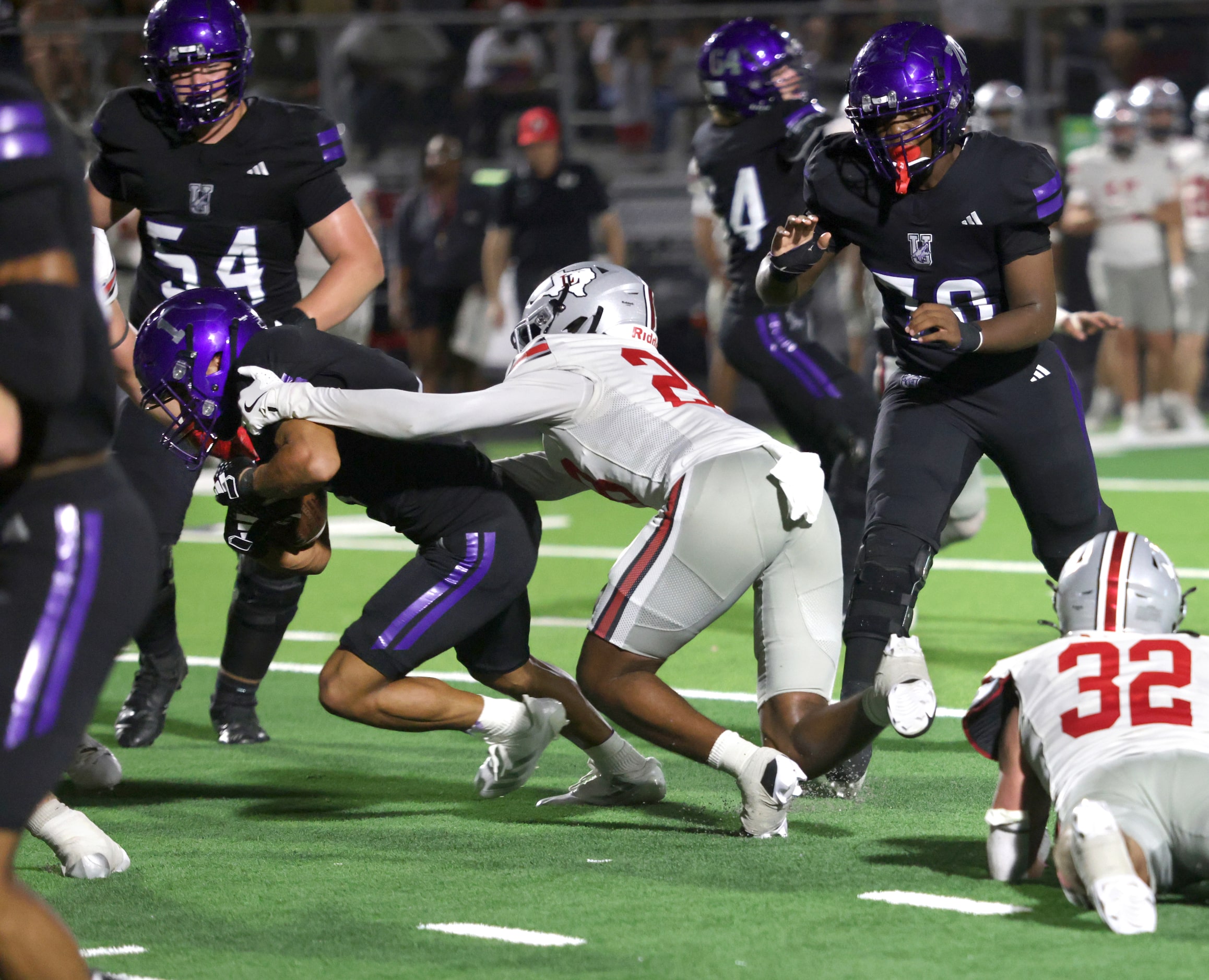 Anna player #1 Edward Chumley tries to gain another couple yards as he's puled down by...