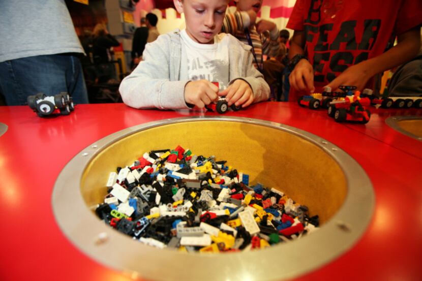 Layne Hooker, 6, of Texarkana, builds a Lego car at the Lego Racers Build & Test area inside...