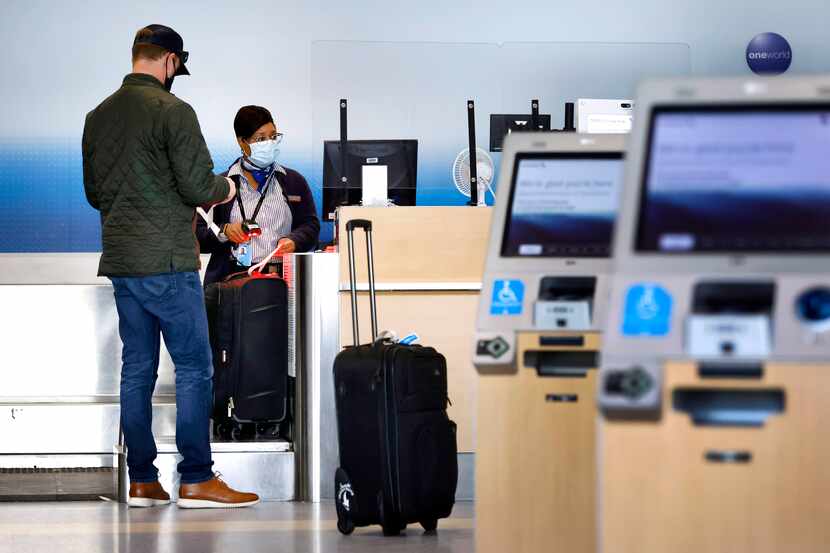 An American Airlines customer assistance representative checks-in a passenger in Terminal A...
