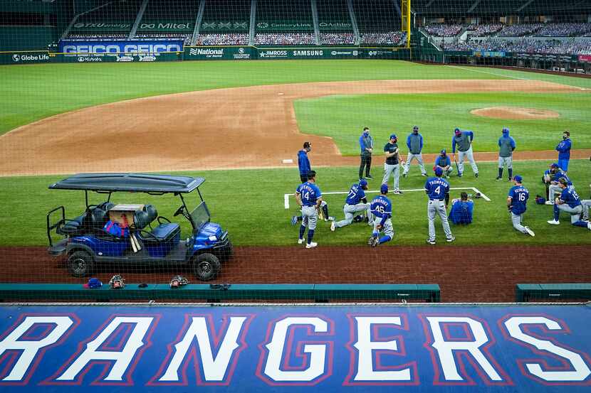 Texas Rangers players gather around field coordinator Matt Hagen following a game at the...