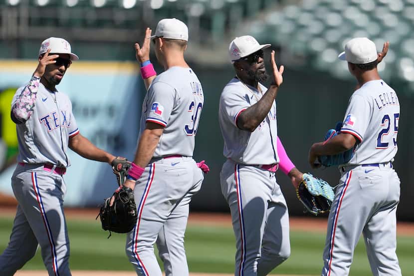 Texas Rangers' Marcus Semien, from left, celebrates with Nathaniel Lowe, Adolis Garcia and...