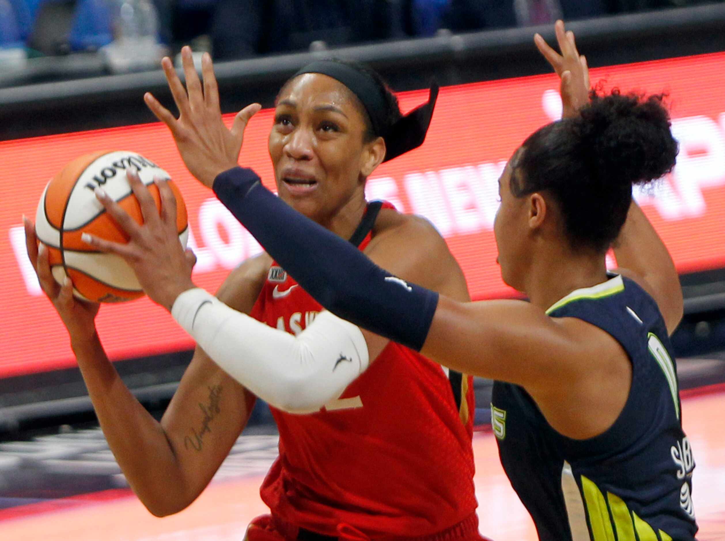 Las Vegas forward A'ja Wilson (22) looks to shoot as she is defended by Dallas Wings forward...