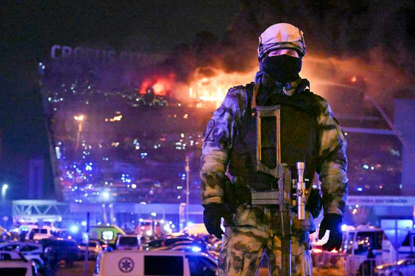 A Russian Rosguardia (National Guard) servicemen secures an area as a massive blaze seen...