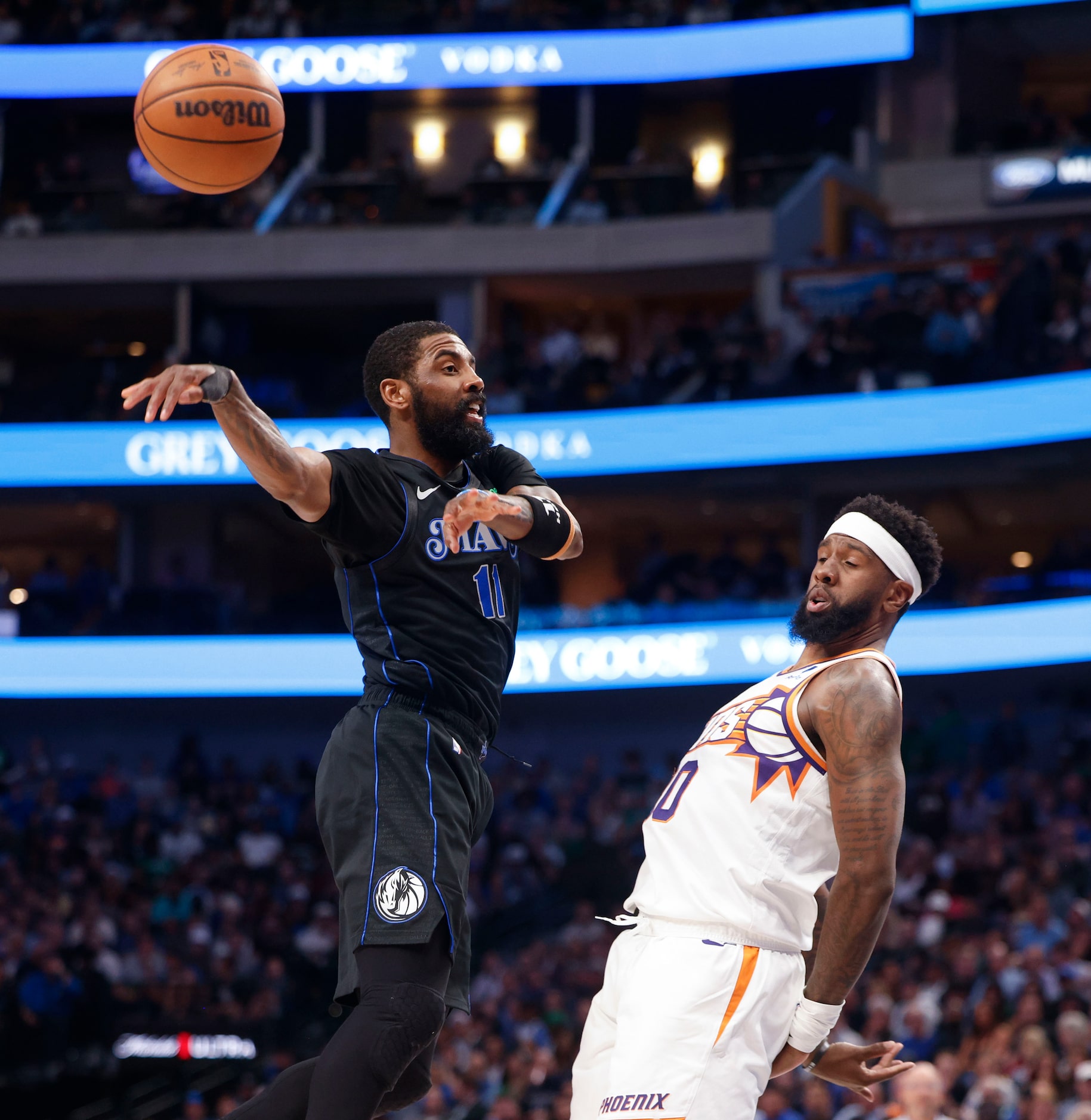 Dallas Mavericks guard Kyrie Irving (11) passes the ball past Phoenix Suns forward Royce...