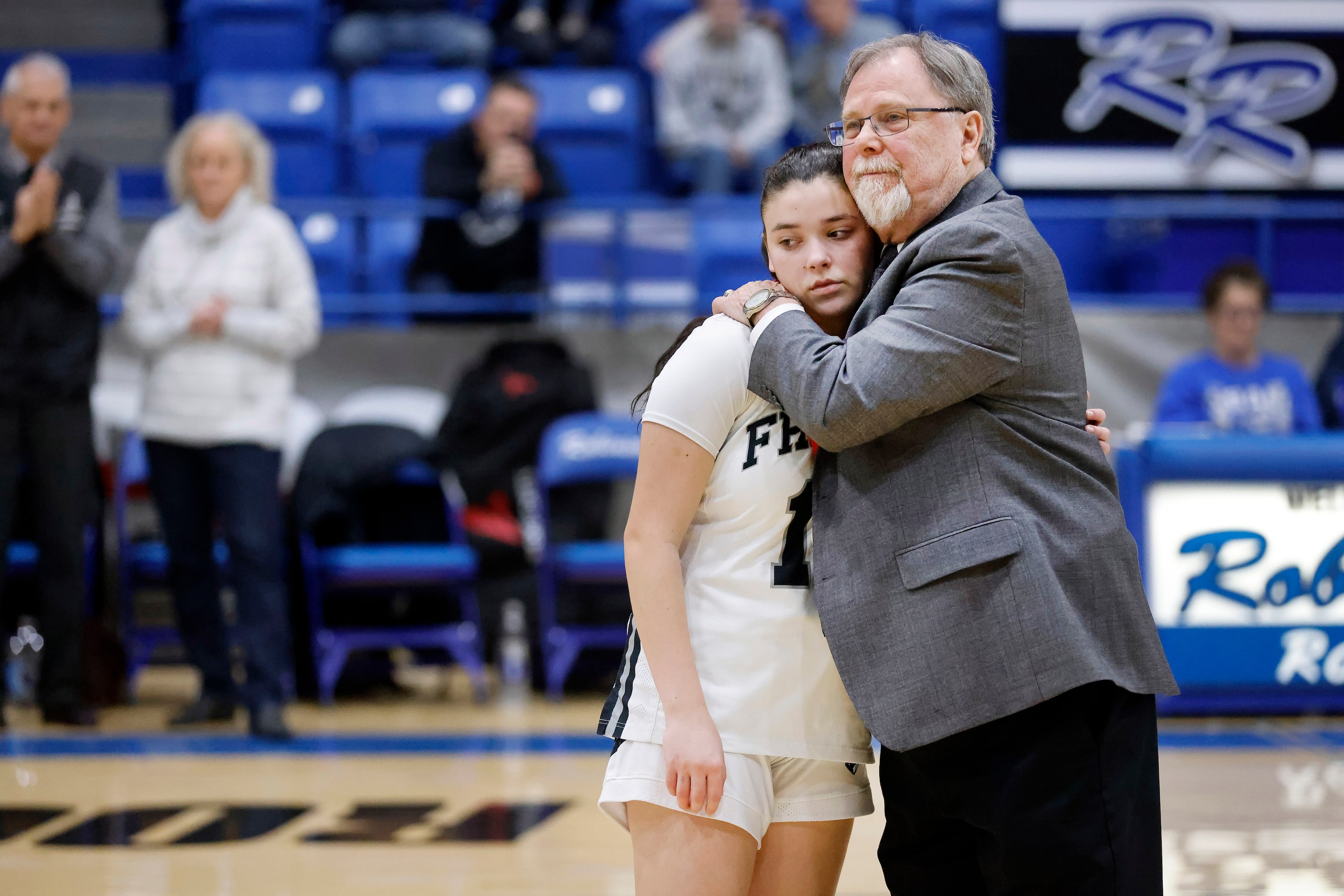 Bishop Lynch head coach Andy Zihlman hugs guard Isabella Piccioni after giving her a medal...