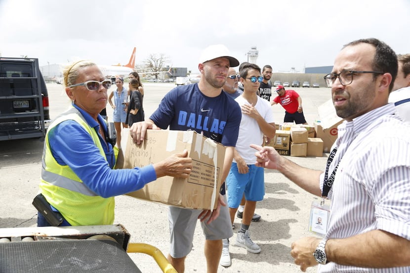 Dallas Mavericks guard J. J. Barea helps unload relief supplies in San Juan, Puerto Rico...