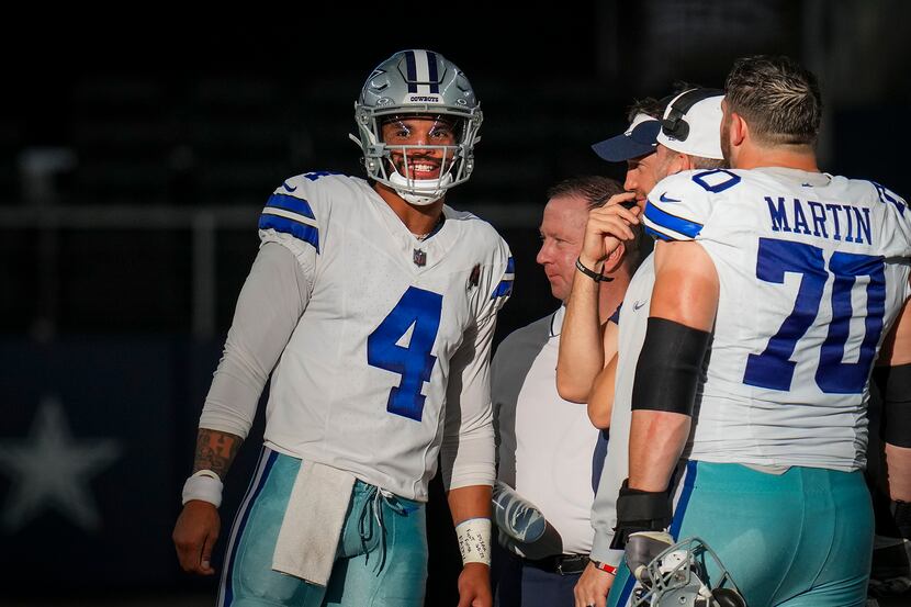 Dallas Cowboys quarterback Dak Prescott (4) smiles as he talks with offensive coordinator...