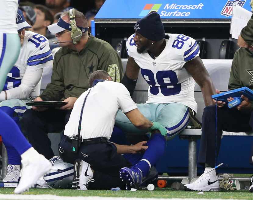 Dallas Cowboys wide receiver Dez Bryant (88) watches the game as his knee is tended to by...