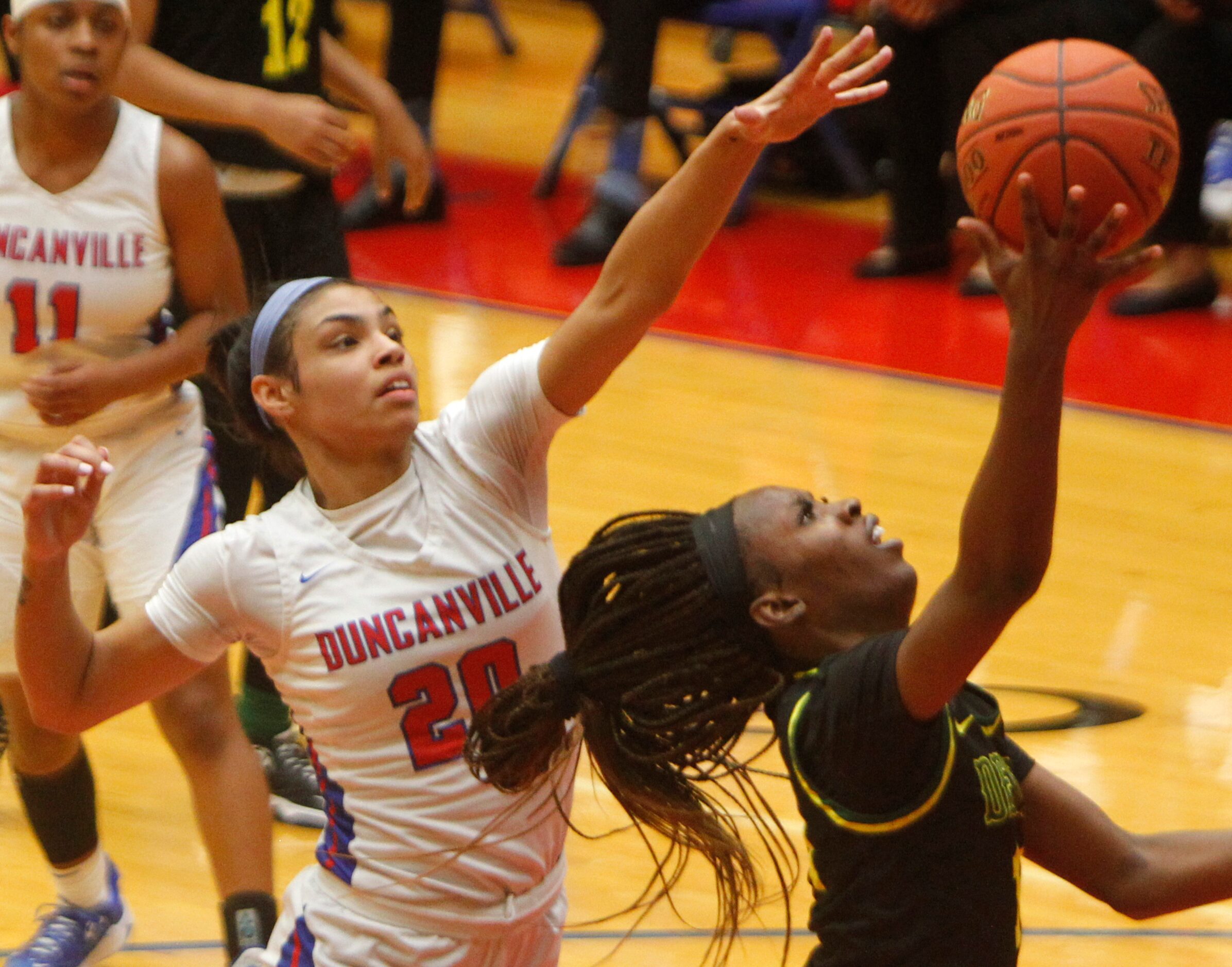 DeSoto's Amina Muhammad (14), right, puts up a shot inside the defense of Duncanville's Maya...