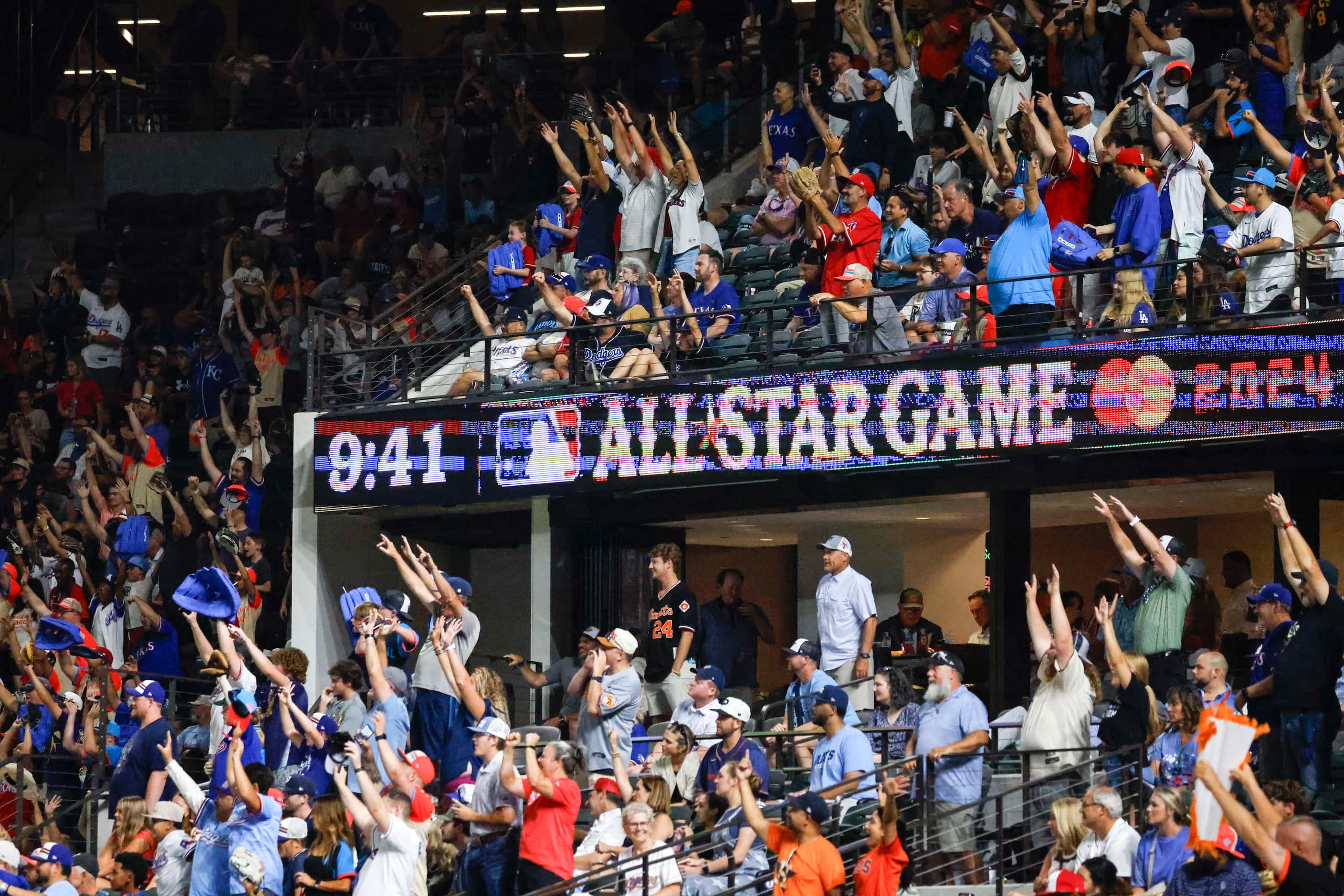 Crowd seeks attention of the players for the ball during MLB All-Star baseball game, on...