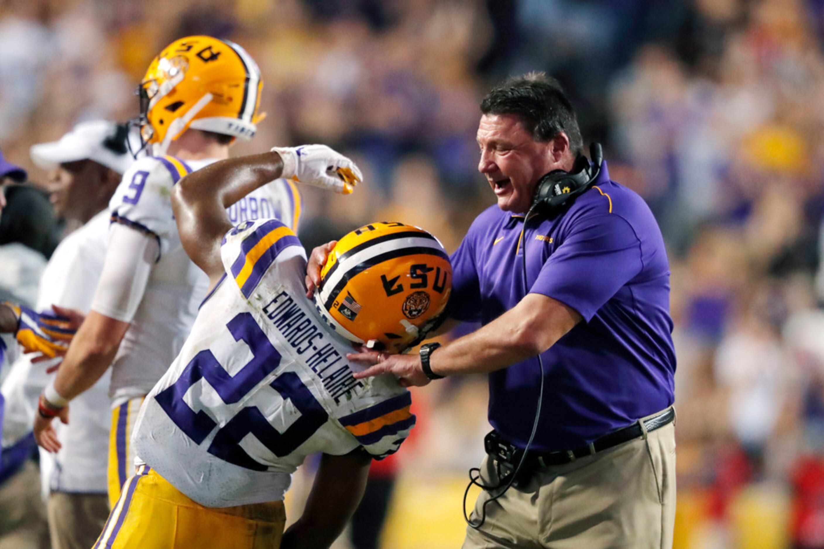 LSU coach Ed Orgeron celebrates with running back Clyde Edwards-Helaire (22) after a...