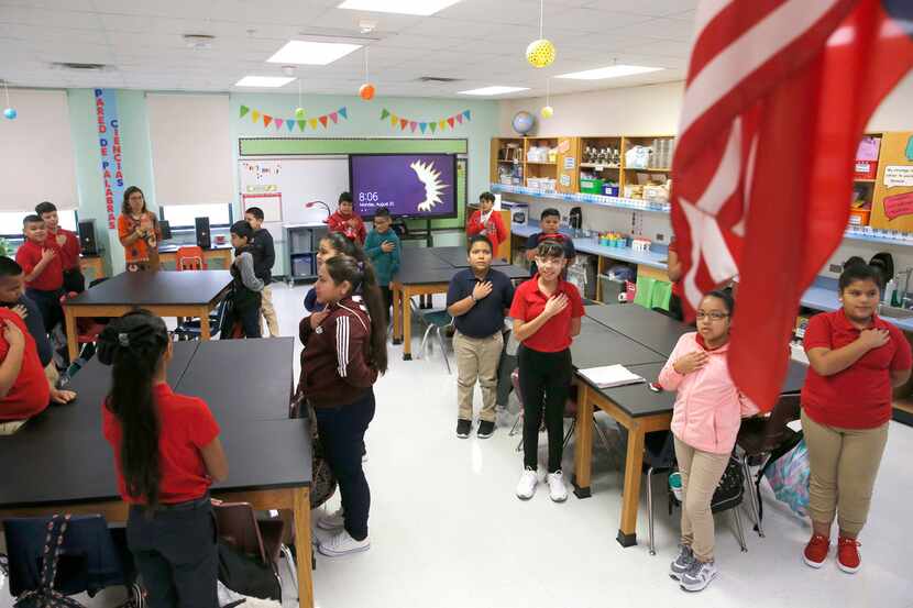 Fifth-graders say the pledge of allegiance during the first day of class at L.O. Donald...