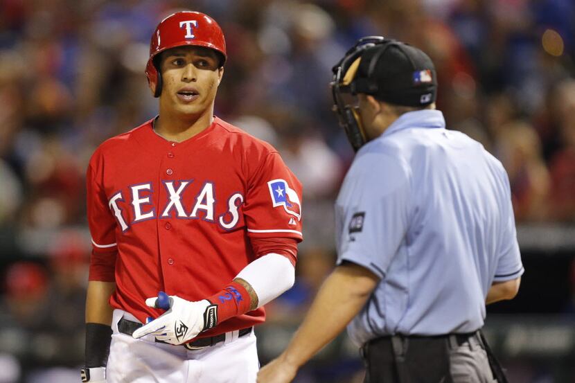 Texas batter Leonys Martin complains to home plate umpire Hal Gibson after being called out...