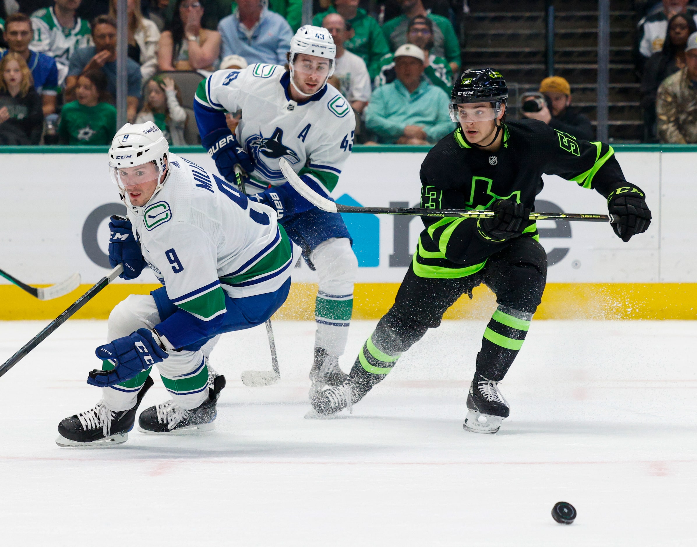 Dallas Stars center Wyatt Johnston (53) and Vancouver Canucks center J.T. Miller (9) race...